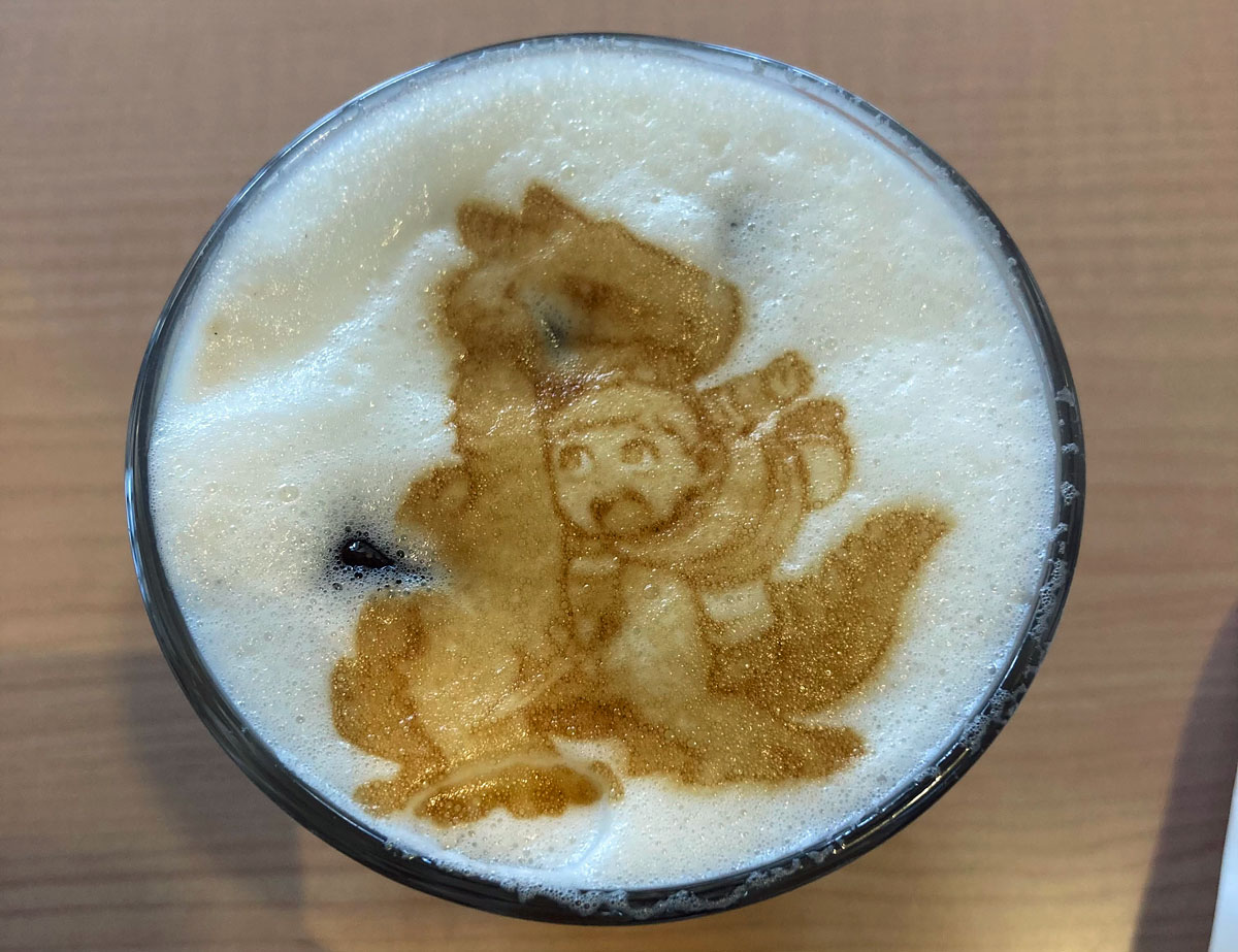 I ordered an iced latte from the “Delicious in Dungeon” cafe with foam art of Laios fighting a dragon.