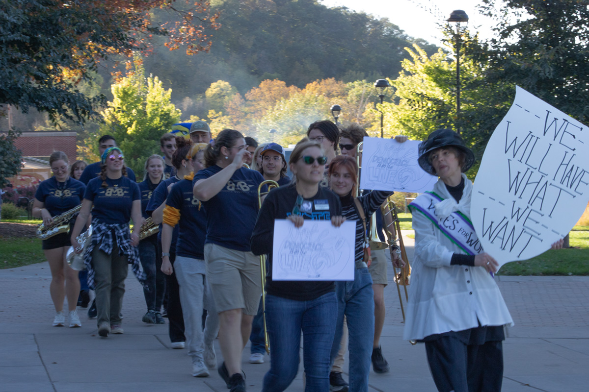 Anna Zook (right), McIntyre Library arts librarian and assistant professor, led a march around campus in a suffragist hat and sash to celebrate the right to vote.