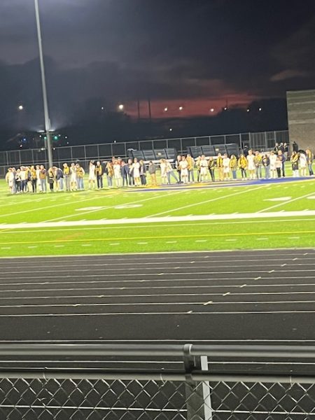  Blugold players are joined on the field by their parents before the game.