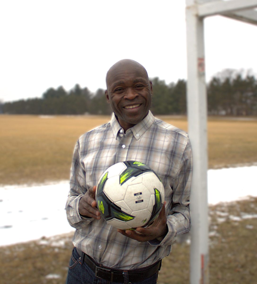 Larry Mboga holding a soccer ball at the Eau Claire Soccer Park, a place he regularly visits.