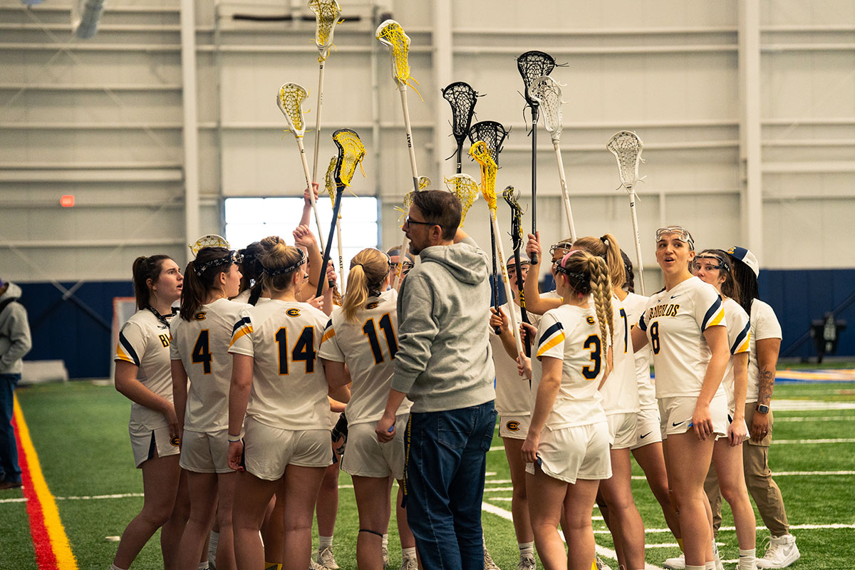 The team goes in for a huddle led by head coach Michael Rhodovi before the start of the game.