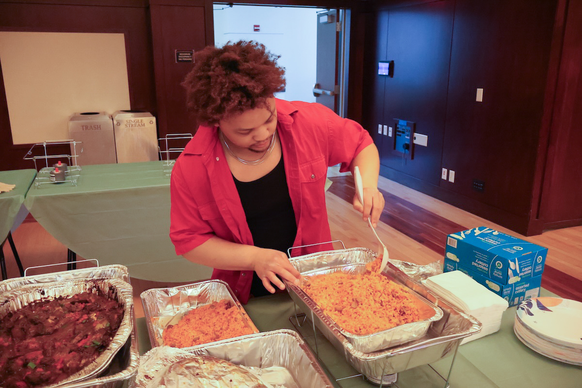 Jay Duell, vice president of the Black Student Union, prepares food for African Dinner attendees. In addition to the food made by Black Student Union members, Nigerian Kitchen and Big Papa’s BBQ served food at the African Dinner.