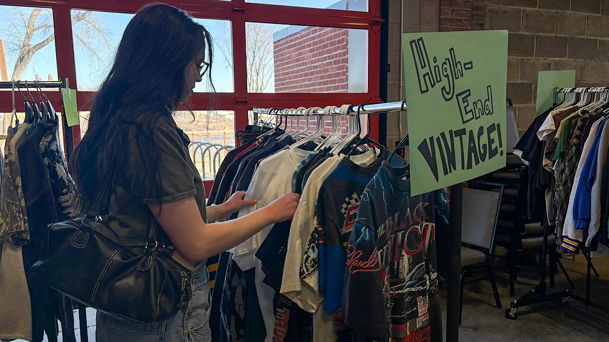 An attendee browses different racks, looking through a multitude of styles. 